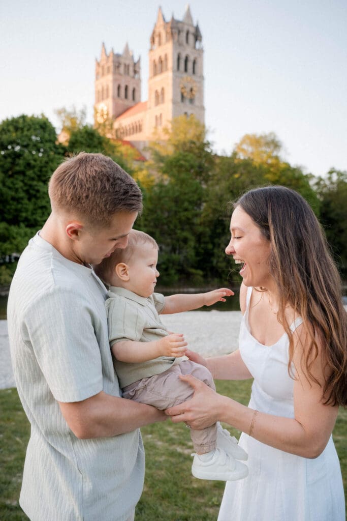 A family plays and laughs together during an outdoor photo session at sunset near St. Maximilian Church in Glockenbachviertal.