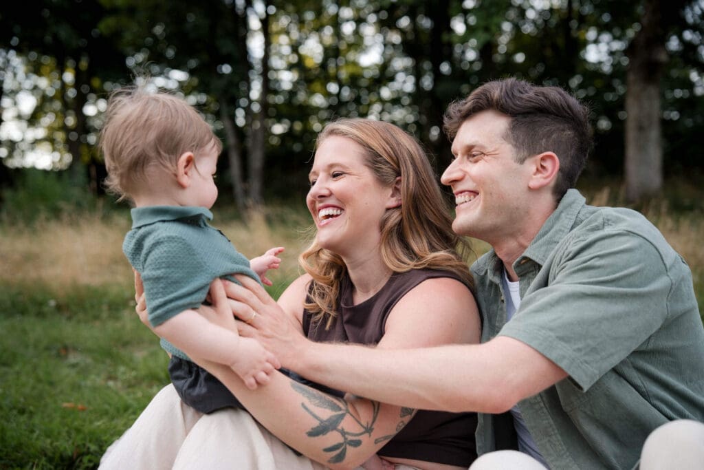 Family laugh together looking at their baby boy during a family photoshoot in Westpark.