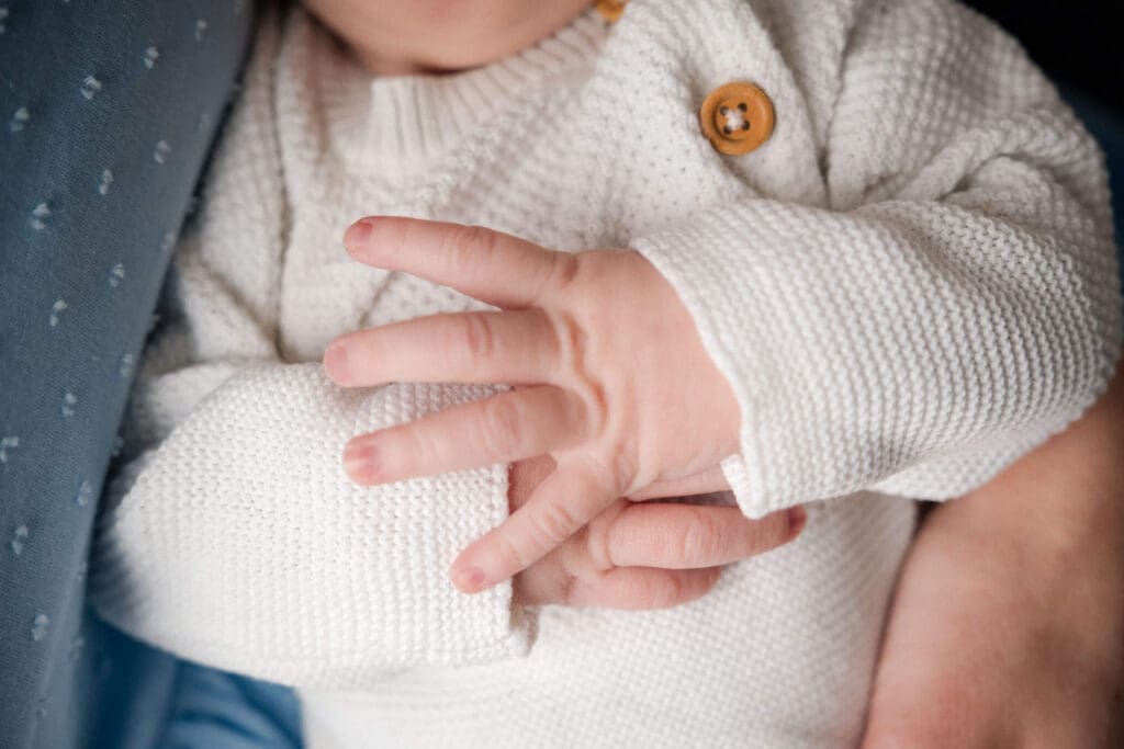 Close up of tiny newborn hands folded on top of each other