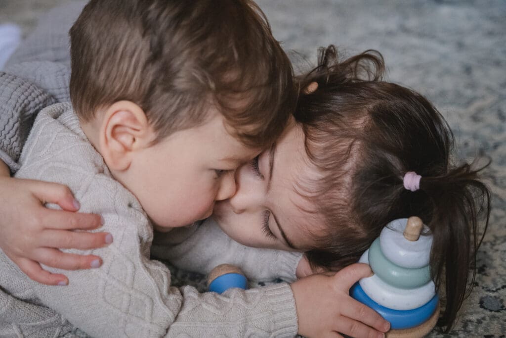 wo toddler siblings hugging and playing together during candid lifestyle photography moment