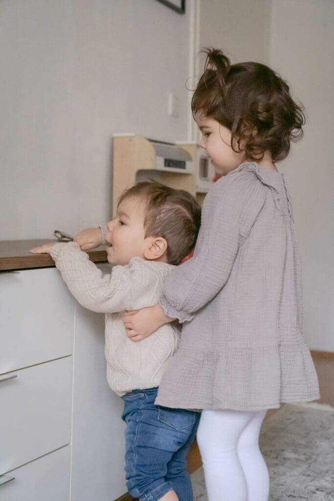 Toddler siblings embracing during authentic family lifestyle photography session at home