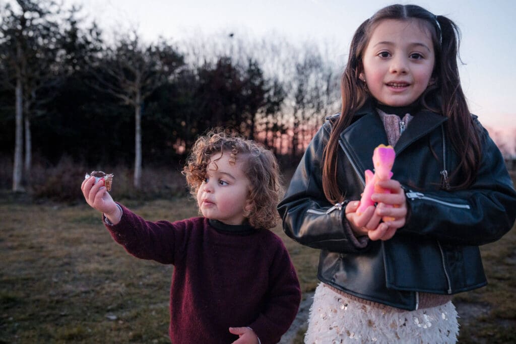 Two children showing excitement while preparing for family photoshoot