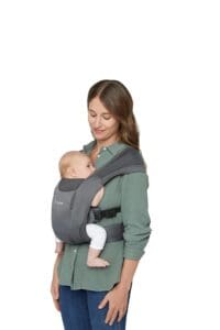 Baby in baby carrier against woman's chest in a green shirt