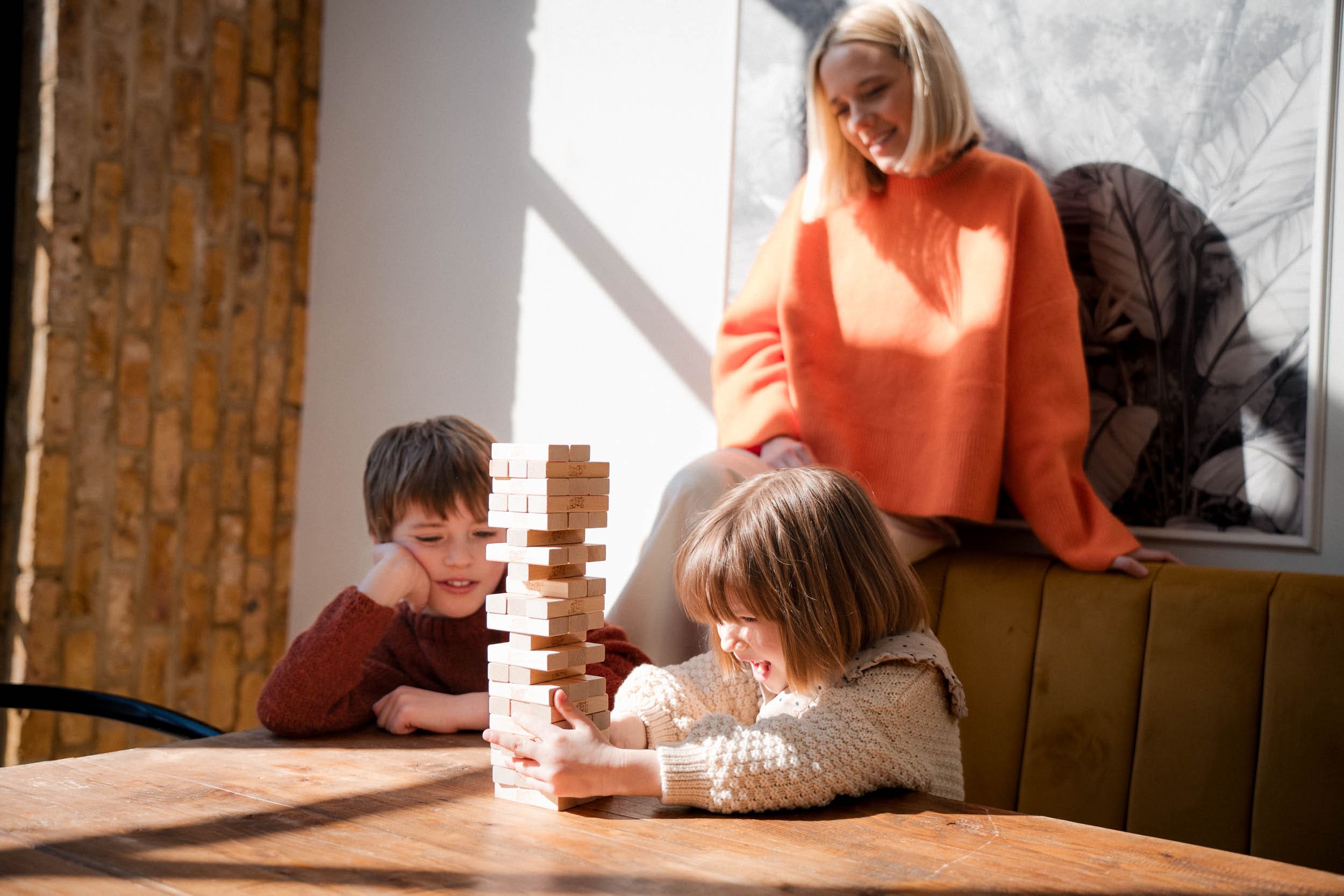 Mother and kids playing Jenga together for natural candid family photos