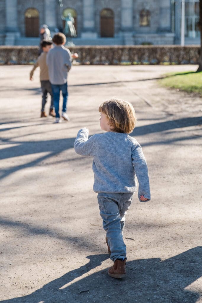 Young boy strides with purpose following his older brothers.