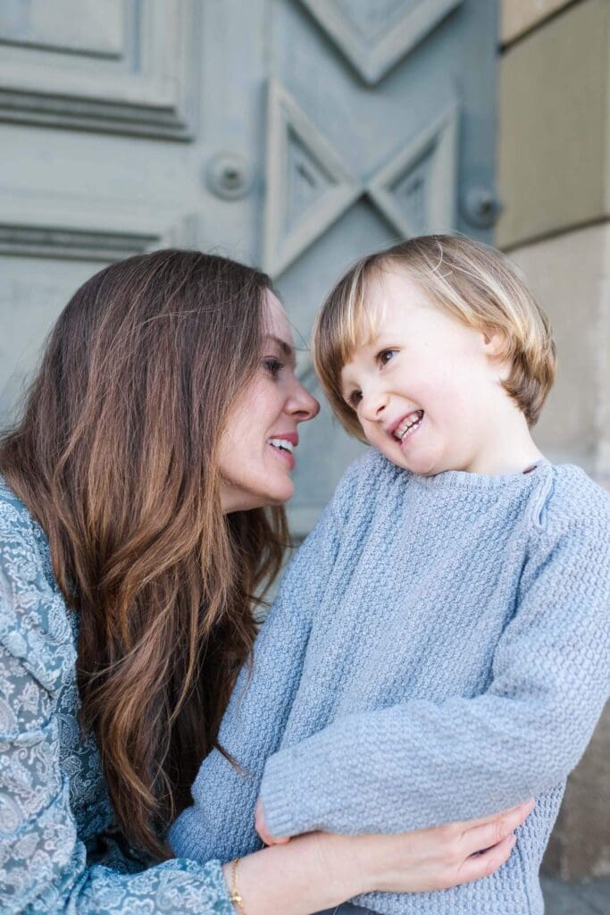 Mom leans in to whisper to little boy's ear
