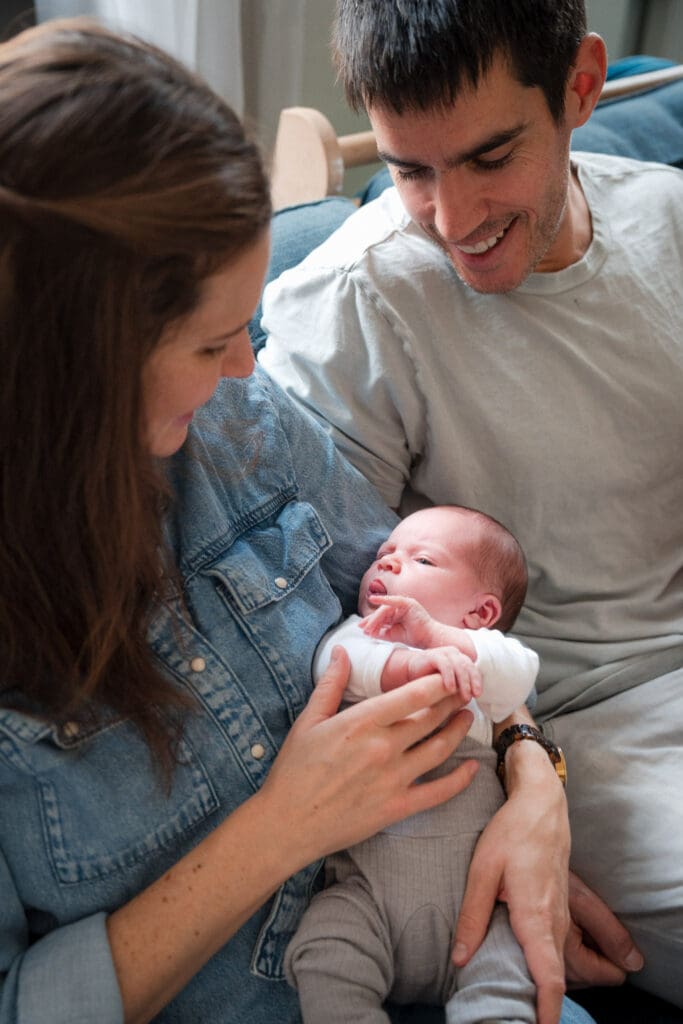 Parents admiring their newborn baby during relaxed in-home photoshoot in Munich