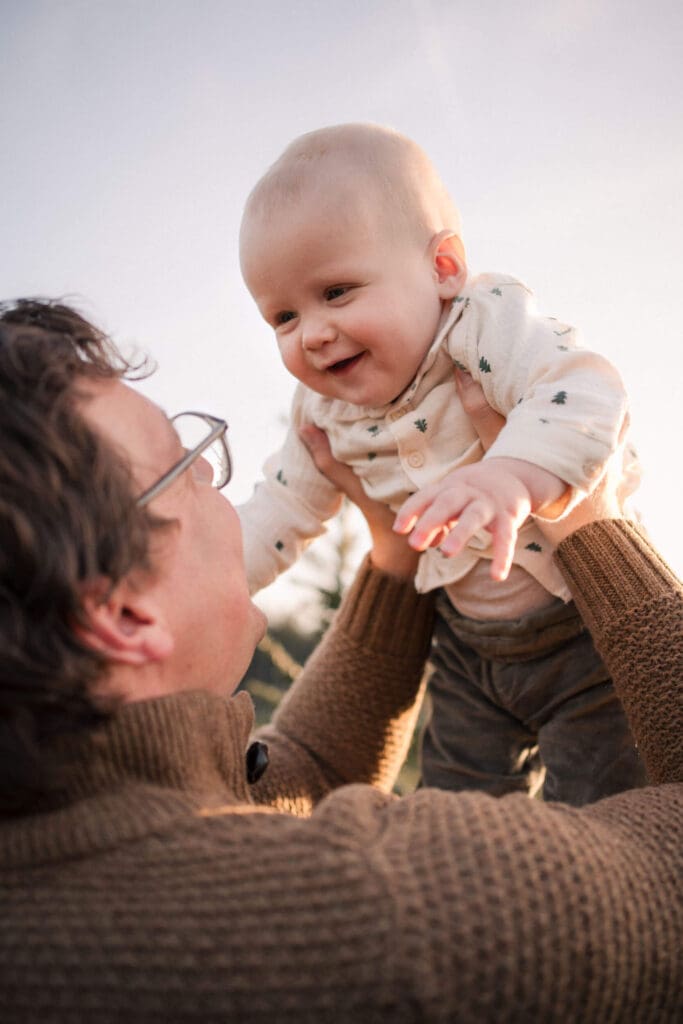 Dad lifting his laughing baby into the air