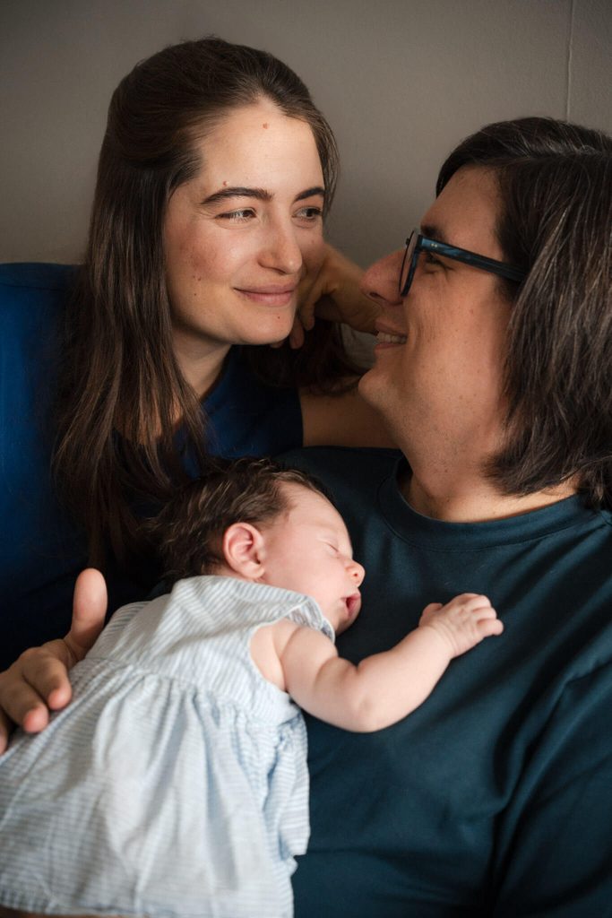 New parents smiling at their baby daughter at home in Munich