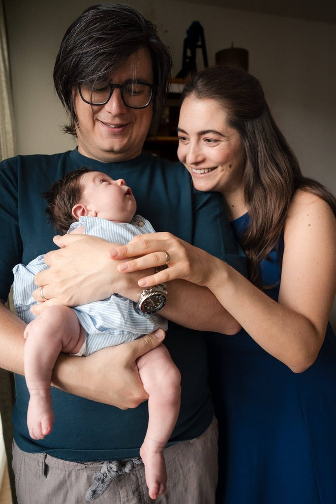 New parents smiling at their baby daughter at home in Munich